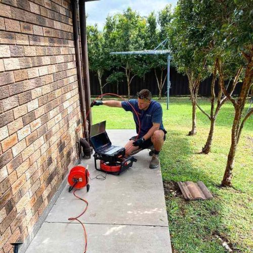 A plumber using a Razorback Drain Camera